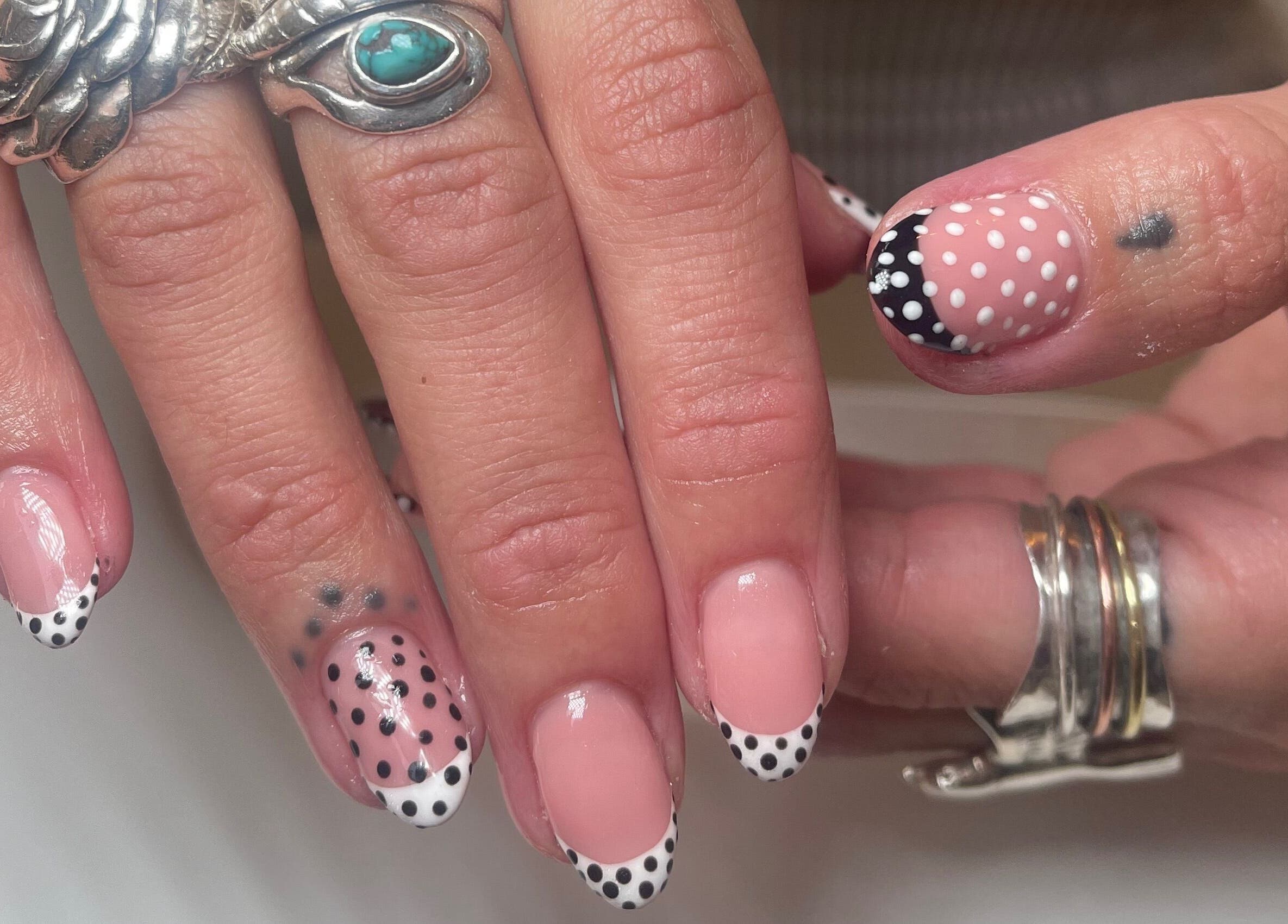 Polka dot nail art at Gee Gee's Beauty in Nantwich, England, GB, featuring elegant silver rings.