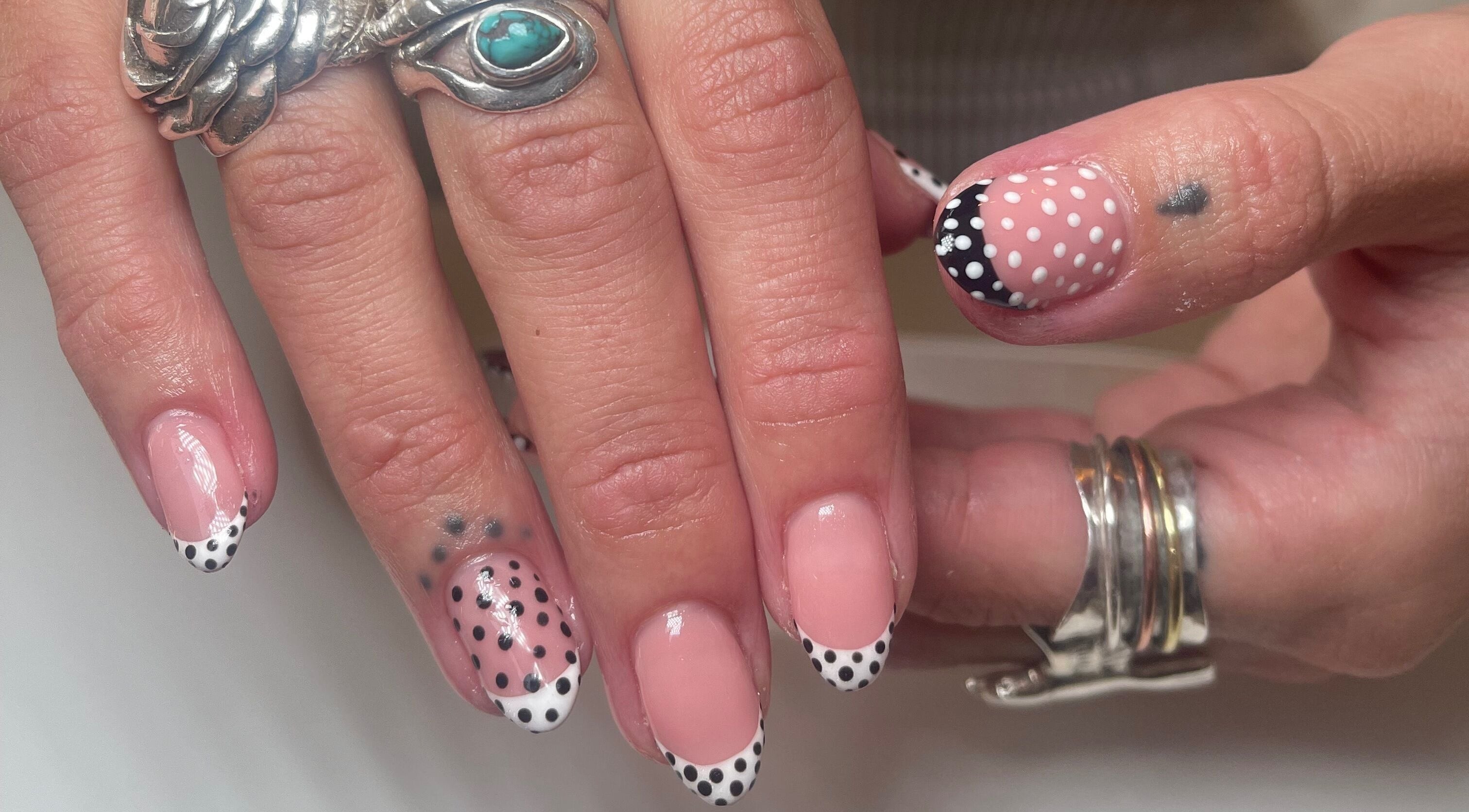 Polka dot nail art at Gee Gee's Beauty in Nantwich, England, GB, featuring elegant silver rings.