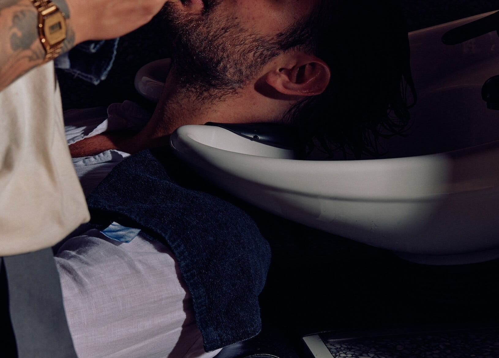 Man receiving a relaxing hair rinse at NOAH Canberra, Canberra, Australian Capital Territory, AU.