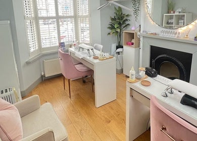 Interior of Cussans Nails & Beauty in Chichester, England, GB featuring elegant nail stations and cozy seating.