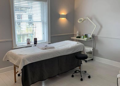 Tranquil treatment room at Cussans Nails & Beauty, Chichester, England, GB with massage table and soft lighting.