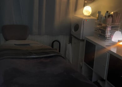 Cozy massage room at Soothe & Glow, Bletchley, England, GB, with ambient lighting and a massage table.
