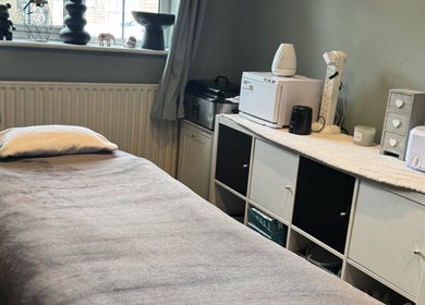 Cozy massage room at Soothe & Glow, Bletchley, England, GB with a soft bed and calming decor.