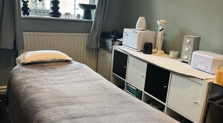 Cozy massage room at Soothe & Glow, Bletchley, England, GB with a soft bed and calming decor.