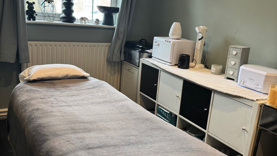 Cozy massage room at Soothe & Glow, Bletchley, England, GB, featuring a plush bed and peaceful decor.