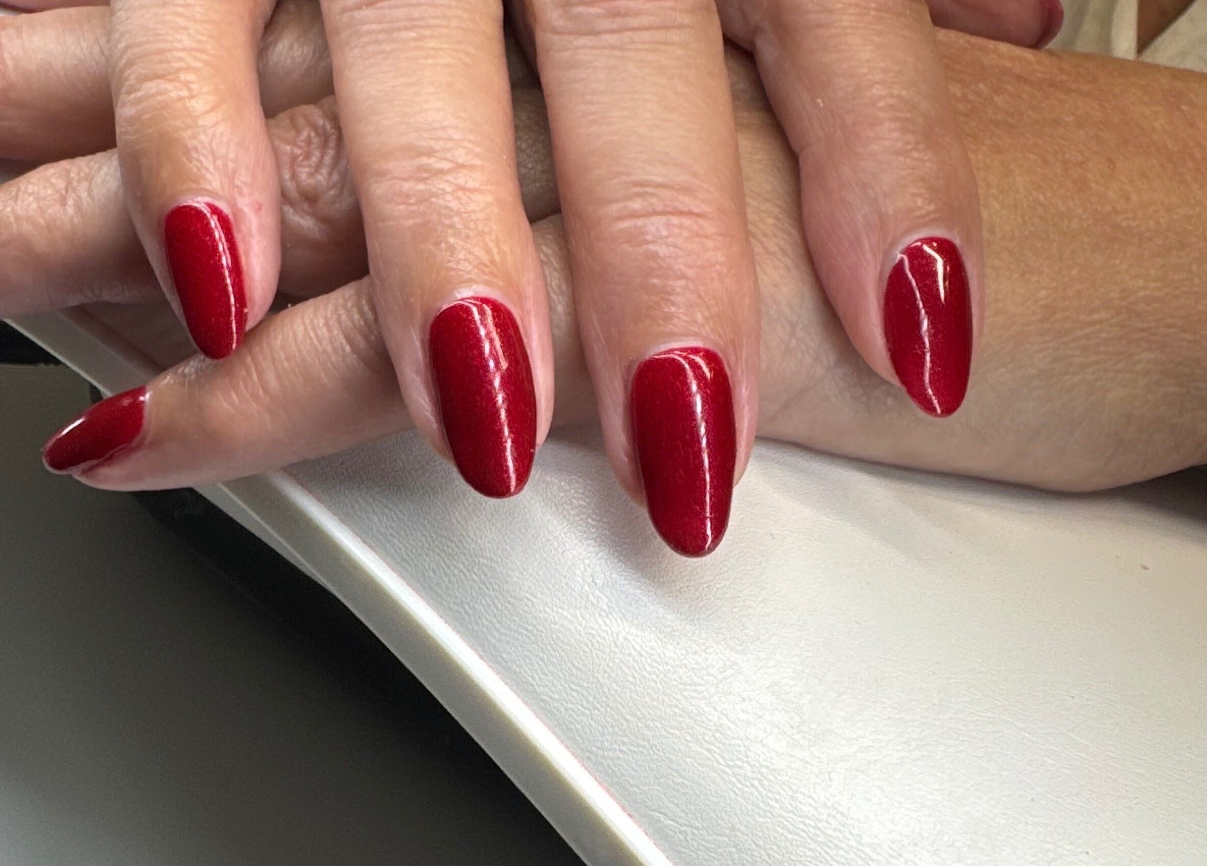 Vibrant red manicure at Soothe & Glow in Bletchley, England, GB showcasing stylish nail design.