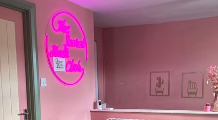 Vibrant pink neon sign inside Jess MUA at Hinckley, England, GB, creating a warm and inviting atmosphere.