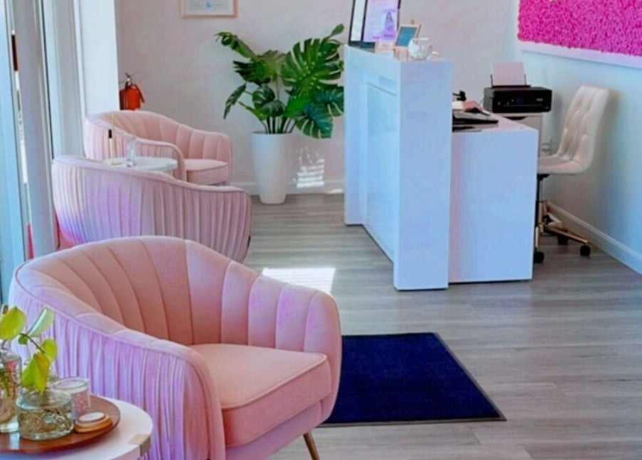 Elegant seating area at Adriana's Permanent Makeup, Wilmington, Massachusetts, US with pink chairs and greenery.