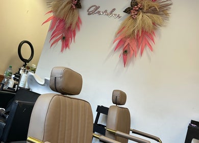 Stylish salon chairs at The Glambar, Glasgow, Scotland, GB with chic wall decor and styling tools.
