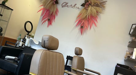 Stylish salon chairs at The Glambar, Glasgow, Scotland, GB with chic wall decor and styling tools.