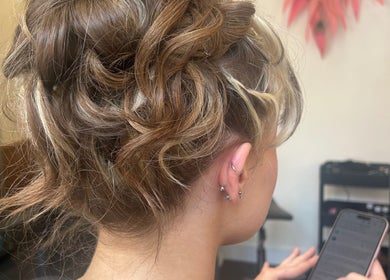 Soft curls styled at The Glambar in Glasgow, Scotland, GB, showcasing a chic and modern updo.