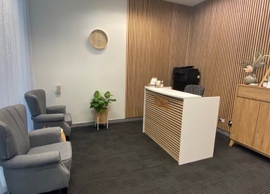 Calm reception area at Resonate Massage and Wellbeing, Holland Park, Queensland, AU with chairs and wooden decor.