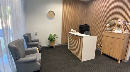 Calm reception area at Resonate Massage and Wellbeing, Holland Park, Queensland, AU with chairs and wooden decor.