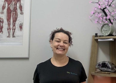 Smiling therapist at Resonate Massage and Wellbeing, Holland Park, Queensland, AU, in a tranquil setting.