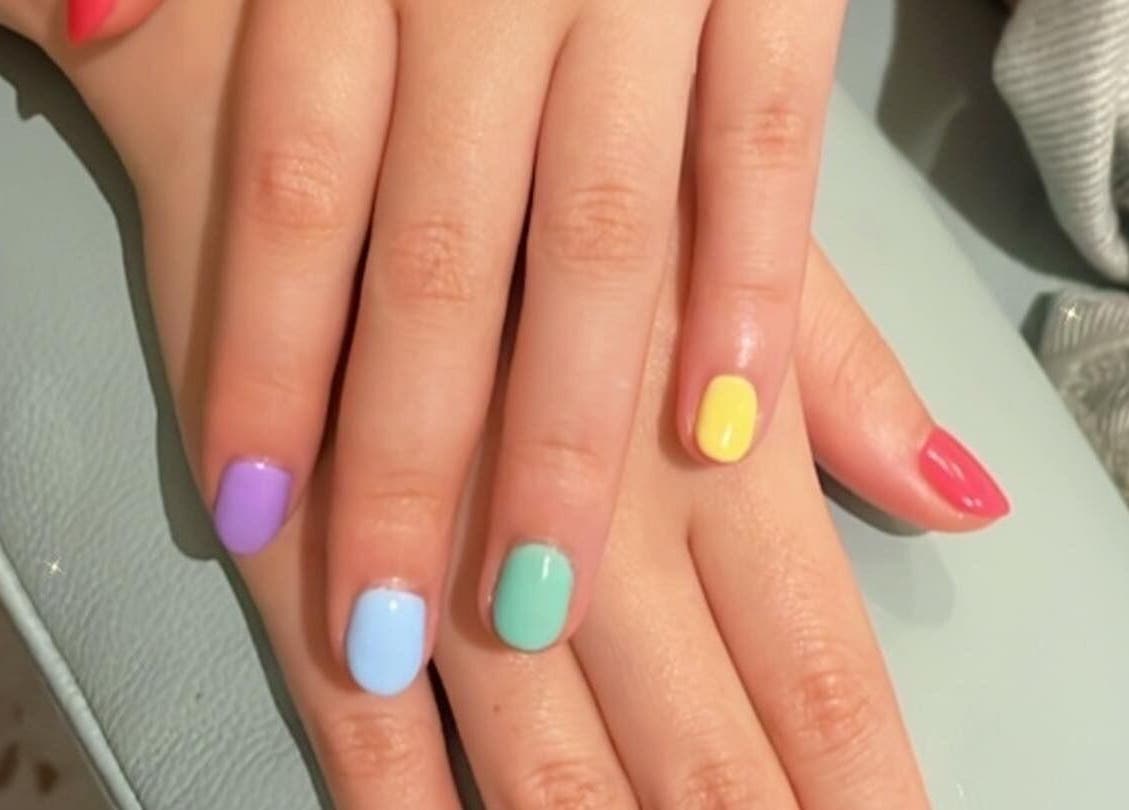 Colorful manicure at ABBY NAIL SALON in Bangkok, TH featuring vibrant red, purple, blue, green, and yellow nails.