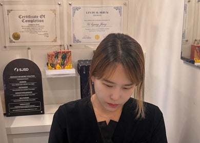 Aesthetician at Browpick Beauty Bar & Spa, Port Moody, BC, CA, with certifications on the wall.