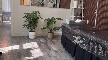 Tranquil treatment room at Browpick Beauty Bar & Spa, Port Moody, British Columbia, CA, with plants and massage bed.