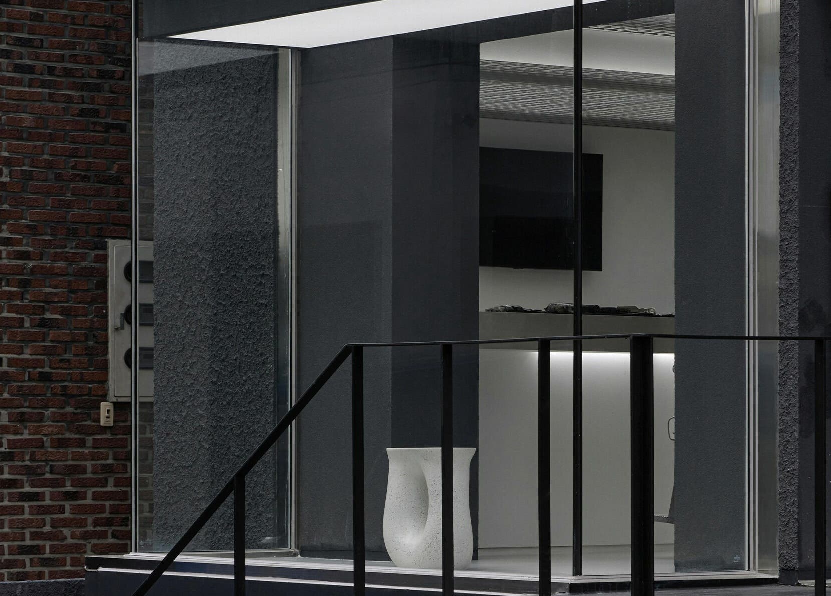 Entrance of LEKKER Hongdae, Seoul, with sleek glass and modern design elements.