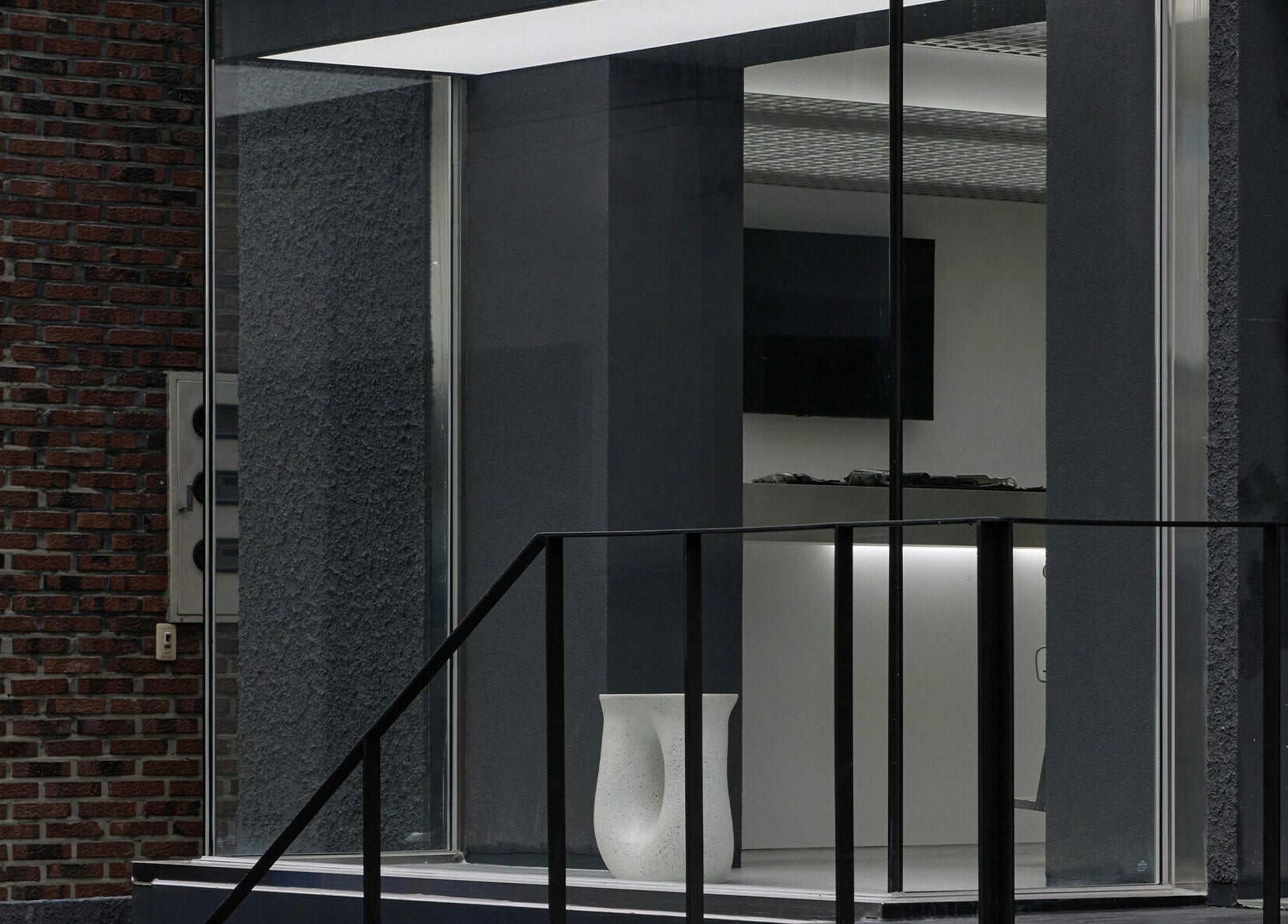 Entrance of LEKKER Hongdae, Seoul, with sleek glass and modern design elements.