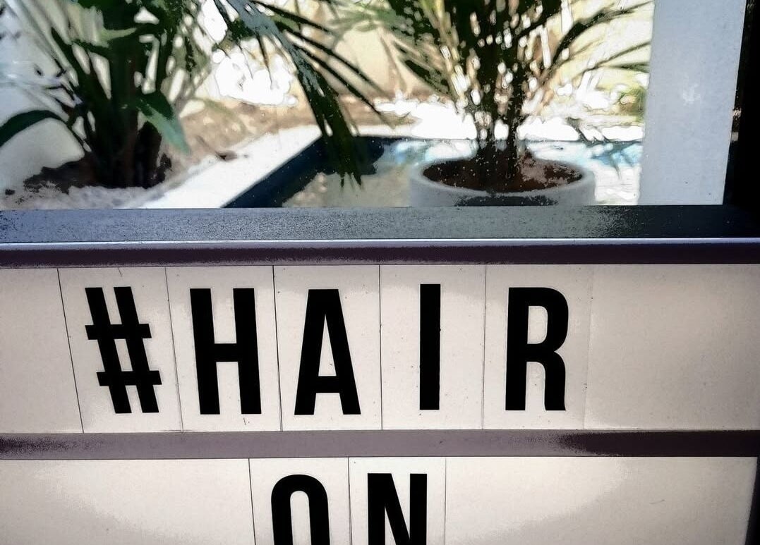 Stylish Hair on Monaco sign with lush greenery background in Zilzie, Australia, AU.