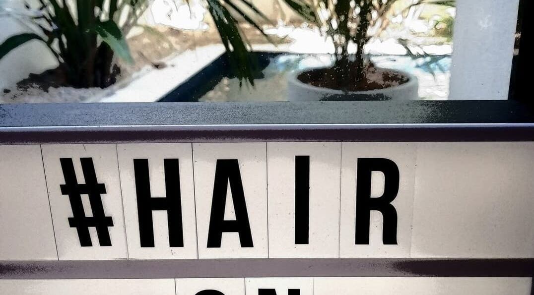 Stylish Hair on Monaco sign with lush greenery background in Zilzie, Australia, AU.