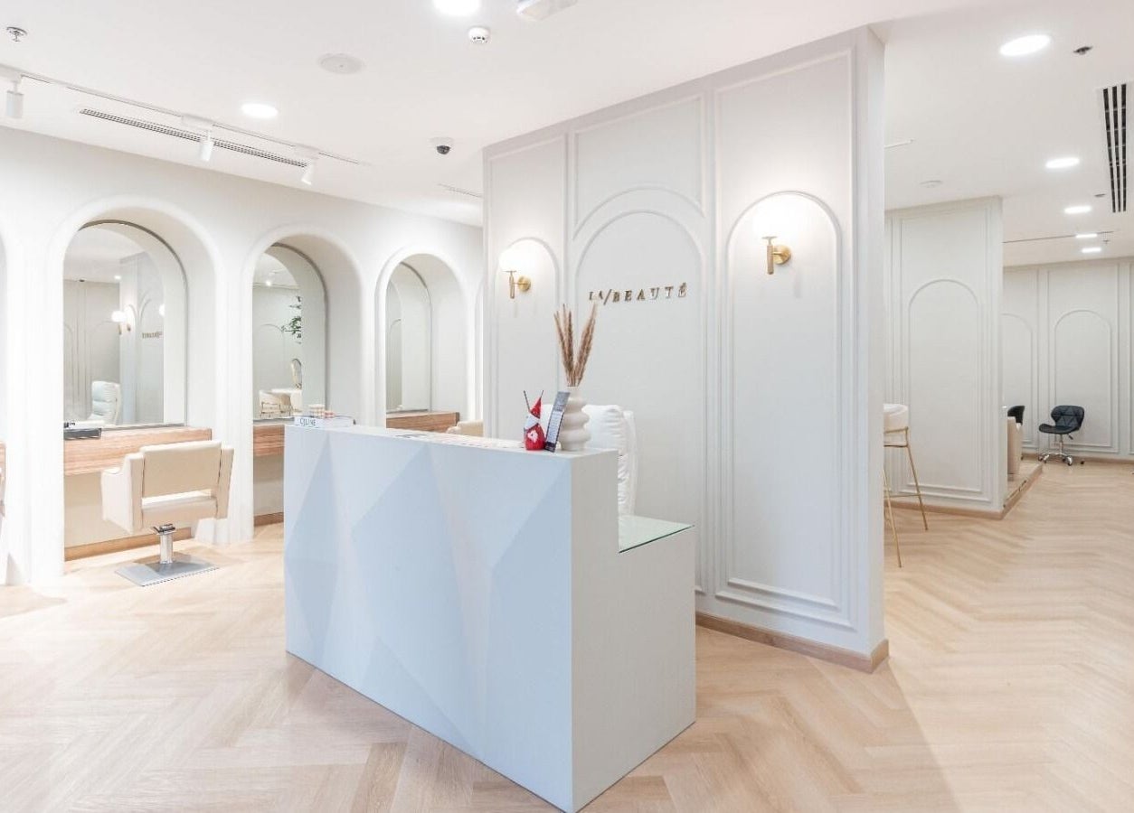 La Beauté's chic reception area in Dubai, AE, with plush seating and elegant decor.