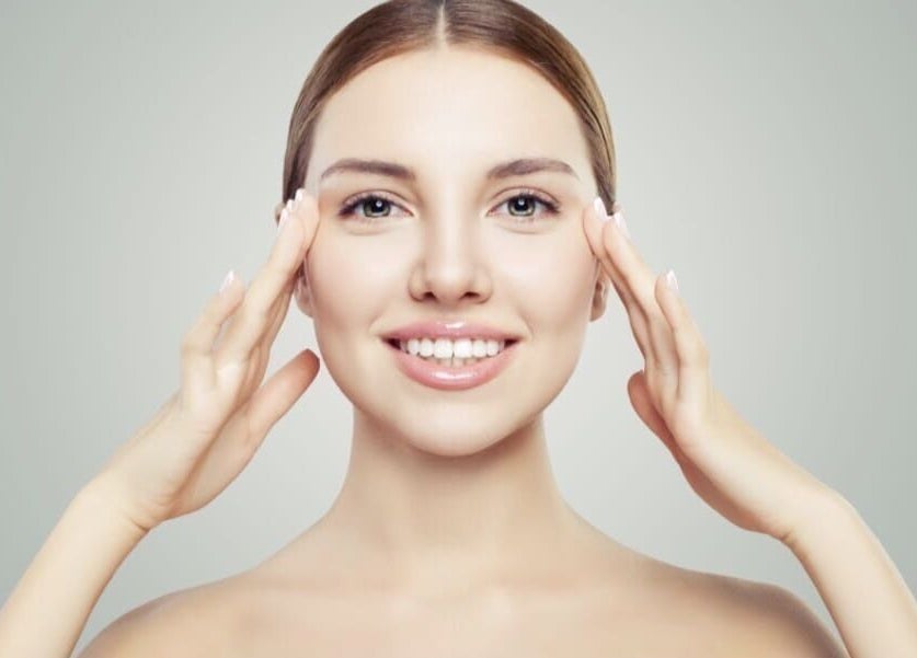 Smiling woman showcasing skincare results at Shape & Glow Aesthetics Birmingham, Birmingham, England, GB.