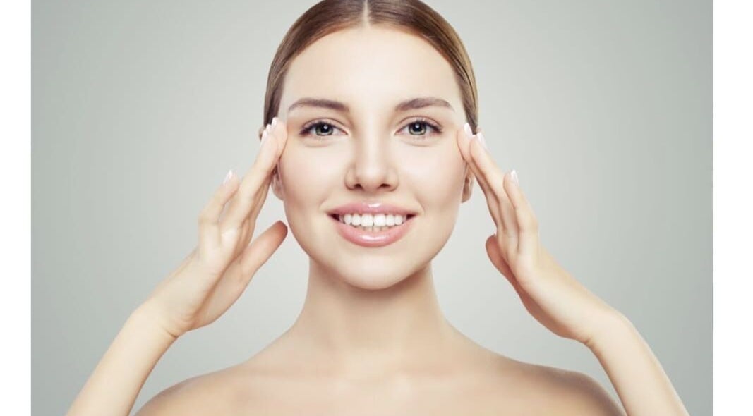 Smiling woman showcasing skincare results at Shape & Glow Aesthetics Birmingham, Birmingham, England, GB.