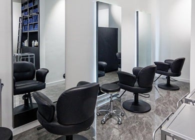 Modern salon interior at Sig Salon in 九龍, 九龍, HK with sleek black chairs and mirrors.
