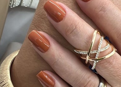 Manicure elegante com esmalte laranja e anéis dourados no Gessy Hair Cabeleireiros, Taubaté, São Paulo, BR.