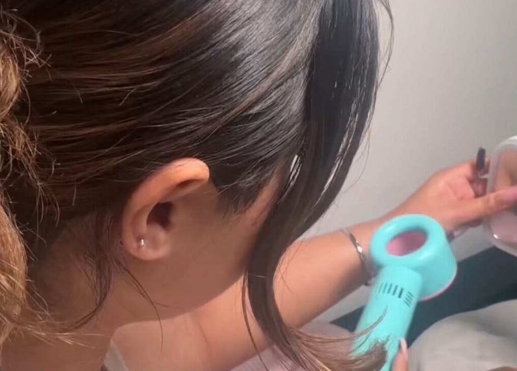 Stylist at Created By Leenah in Purfleet, England, GB uses a blow dryer for precision styling.