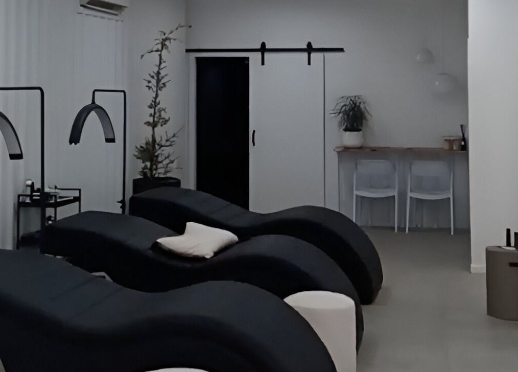Relaxing treatment room at Lainey Everett Aesthetics in Whangaparāoa, Auckland, NZ with modern black loungers.