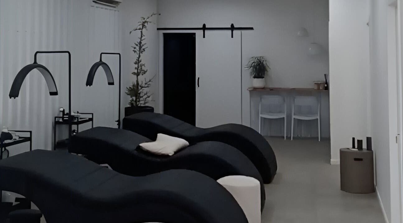 Relaxing treatment room at Lainey Everett Aesthetics in Whangaparāoa, Auckland, NZ with modern black loungers.