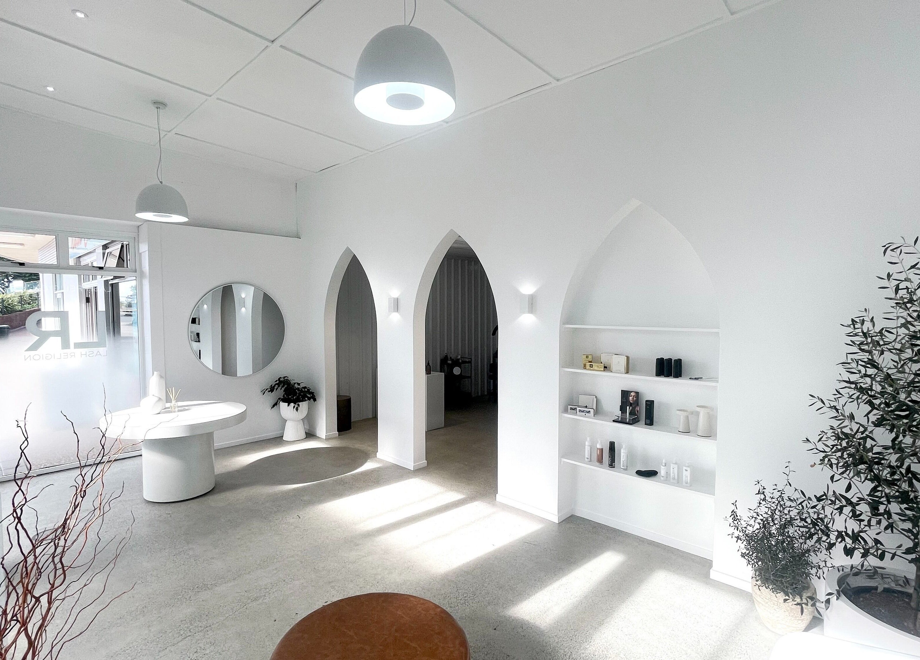 Bright interior of Lainey Everett Aesthetics, Whangaparāoa, Auckland, NZ with modern decor and archway architecture.