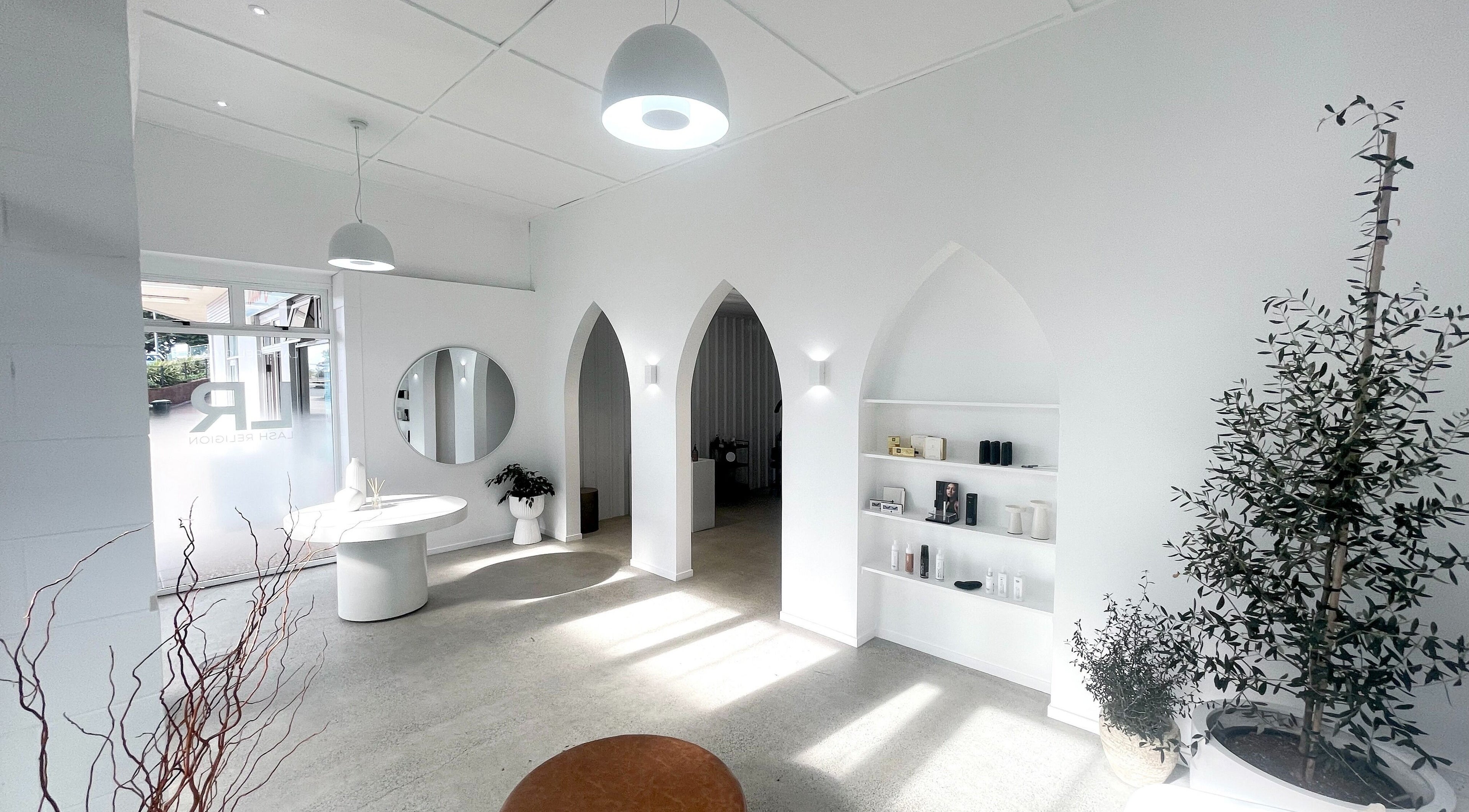 Bright interior of Lainey Everett Aesthetics, Whangaparāoa, Auckland, NZ with modern decor and archway architecture.