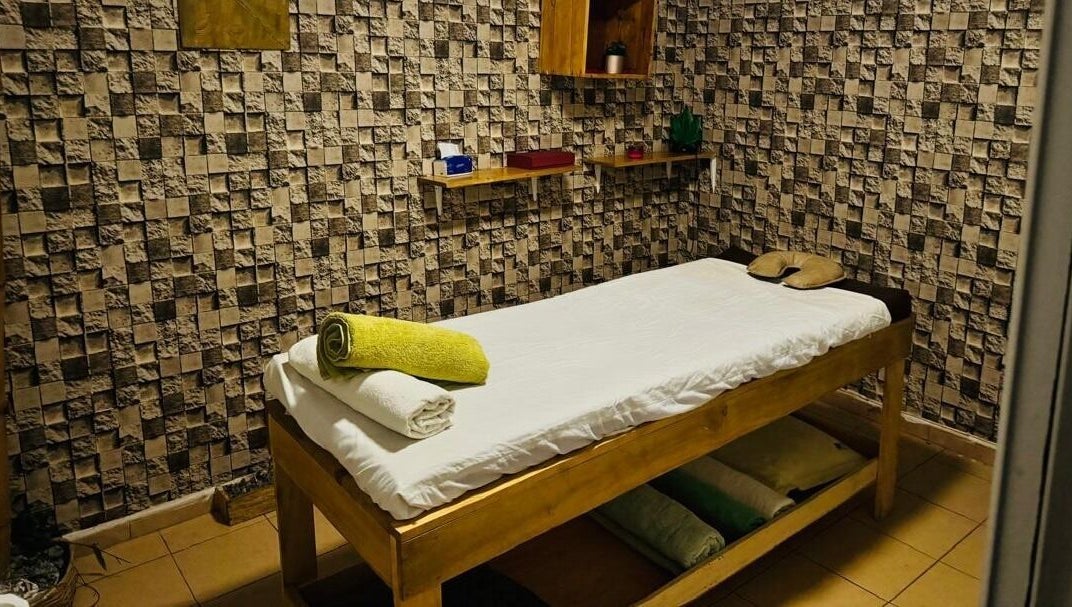 Lit de massage chez MINA SPA Kipe à Conakry, Conakry, GN avec décoration murale relaxante.
