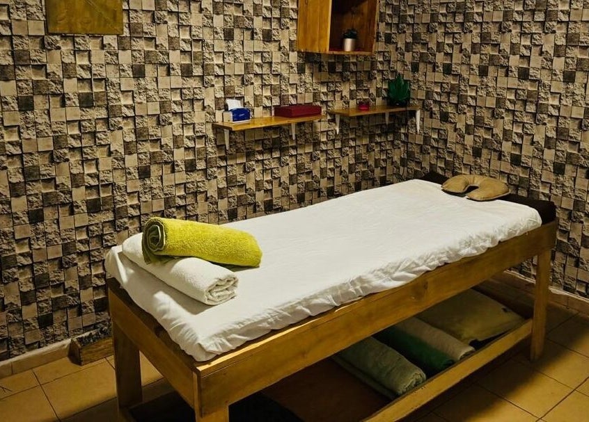 Lit de massage chez MINA SPA Kipe à Conakry, Conakry, GN avec décoration murale relaxante.