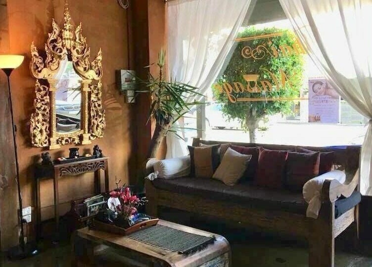 Relaxing lounge area at Forget Me Not Thai Massage, Melbourne, Victoria, AU, featuring ornate mirror and cozy seating.