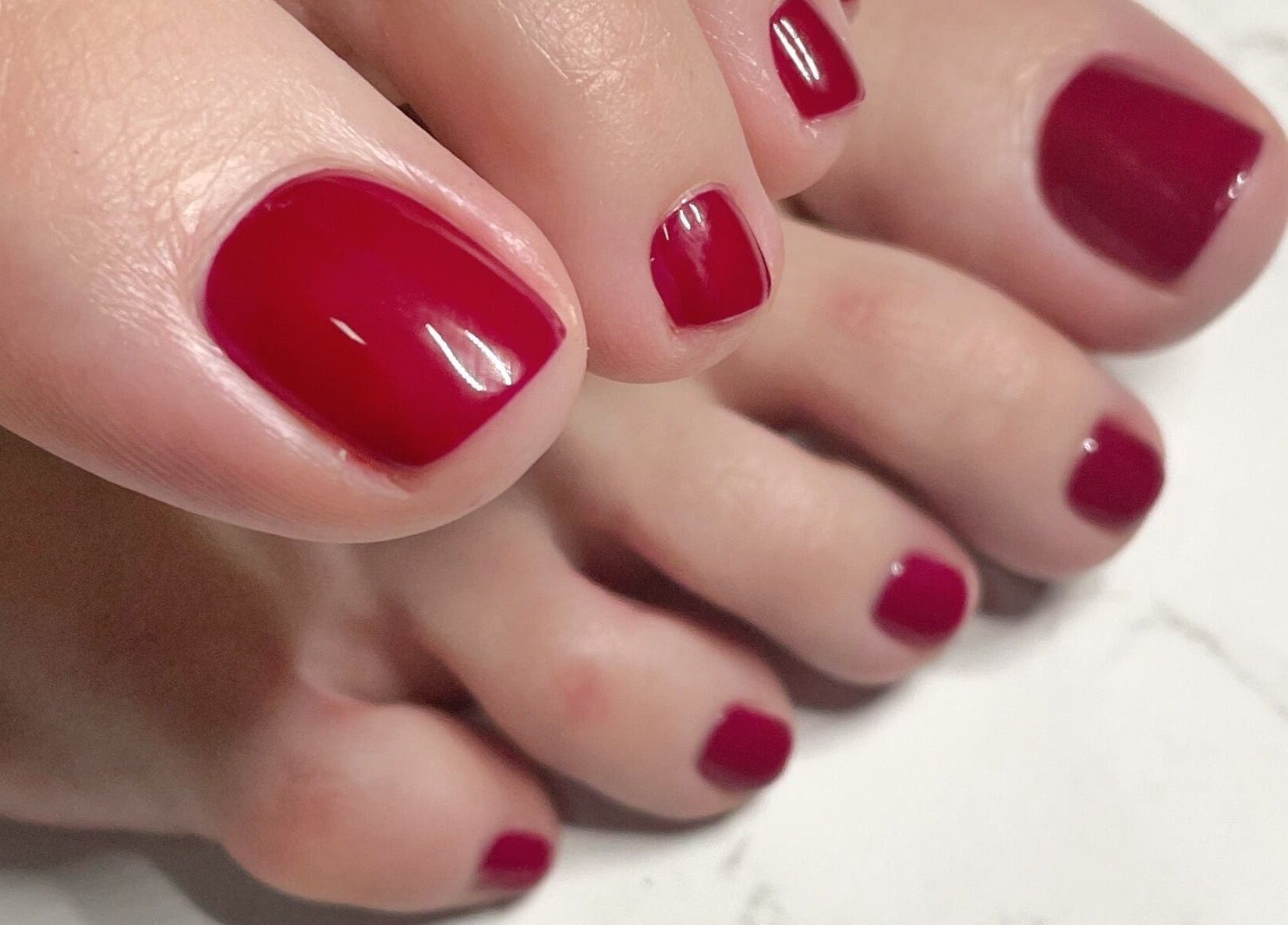 Rote Pediküre bei Krasota.Hamburg in Hamburg, Hamburg, DE. Gepflegte Nägel auf Marmorhintergrund.