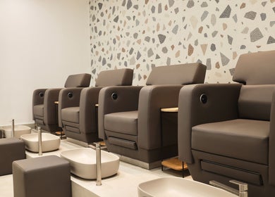 Luxurious pedicure station at Essential Beauty Salon in Dubai, Dubai, AE with modern seating and foot baths.