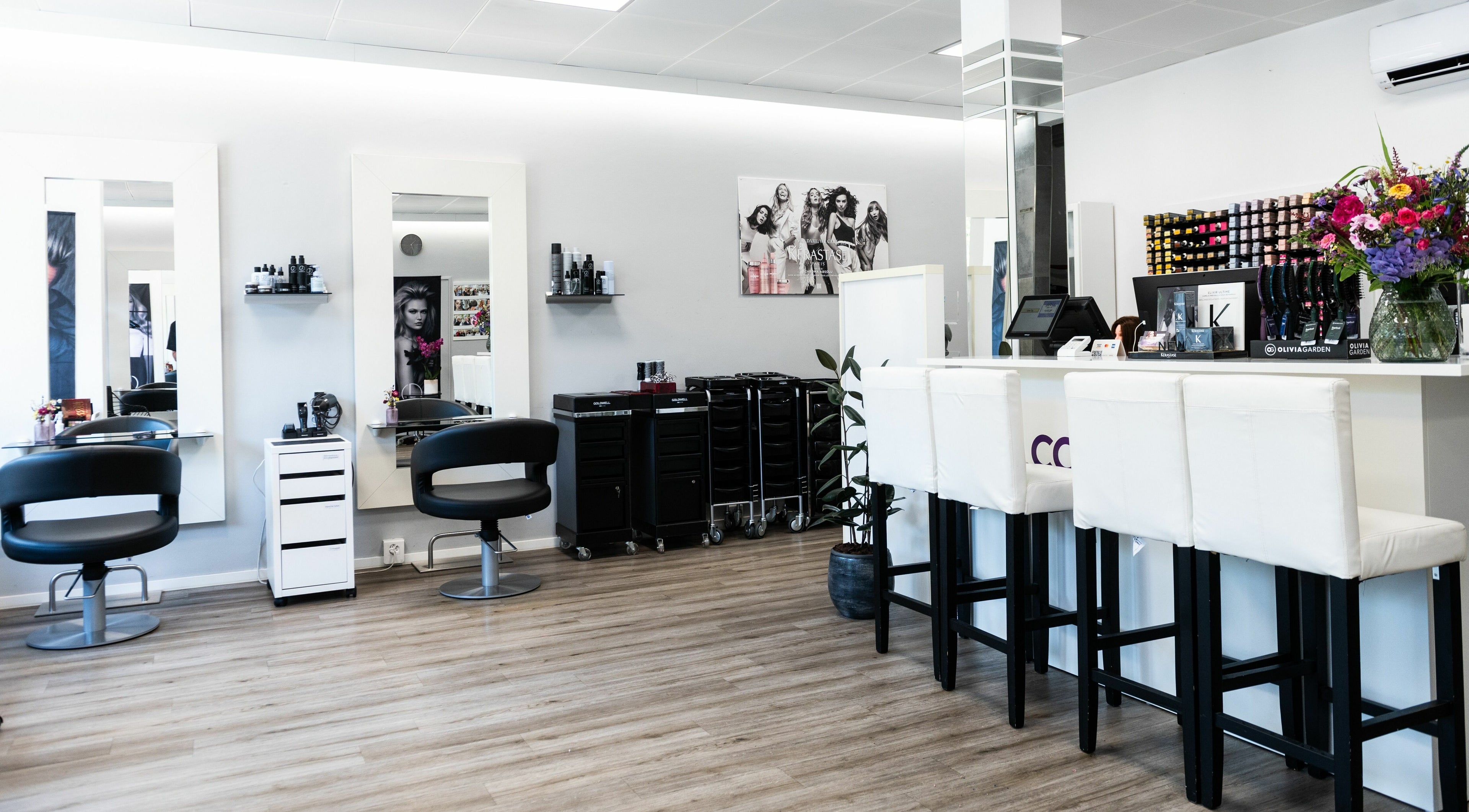 Moderner Innenraum von Color Bar Wettingen, Aargau, CH mit stilvollen Friseurstühlen und Spiegeln.