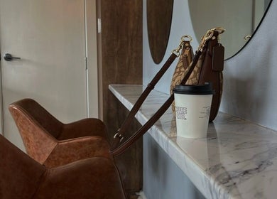 Stylish interior of J Fernandez Hair in Melbourne, Victoria, AU with leather chairs and a marble counter.