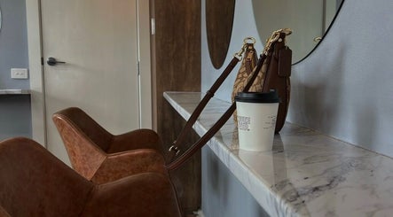 Stylish interior of J Fernandez Hair in Melbourne, Victoria, AU with leather chairs and a marble counter.