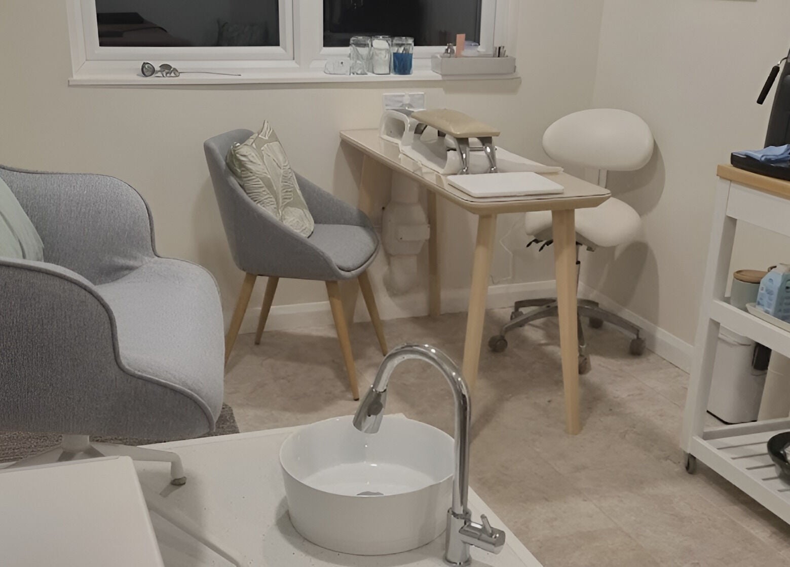 Cozy spa setup in The Rose Room, Westergate, England, GB with chairs, sink, and shelves.