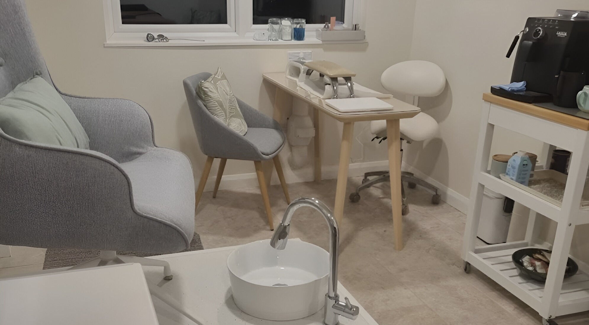 Cozy spa setup in The Rose Room, Westergate, England, GB with chairs, sink, and shelves.
