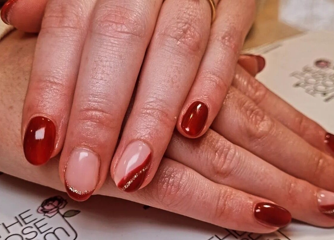 Stylish nail art at The Rose Room in Westergate, England, GB featuring red and nude designs.