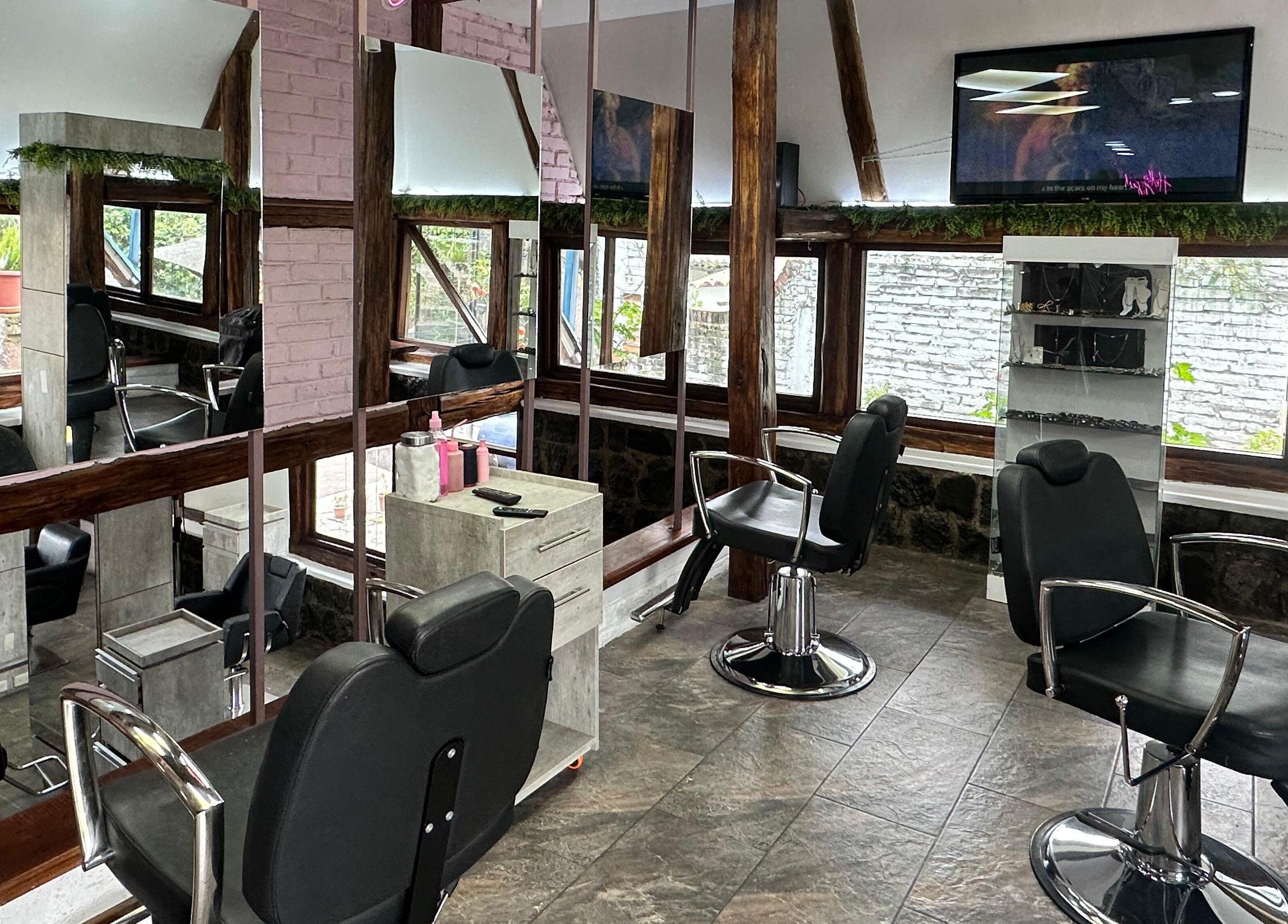 Interior moderno de Beauty House en Quito, Pichincha, EC con sillas de peluquería y espejos grandes.