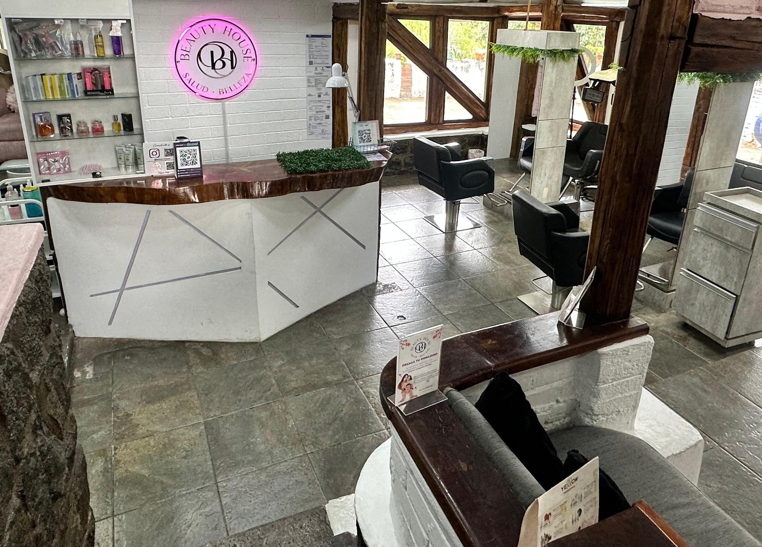 Interior moderno de Beauty House en Quito, Pichincha, EC, destacando la elegante recepción y muebles de salón.