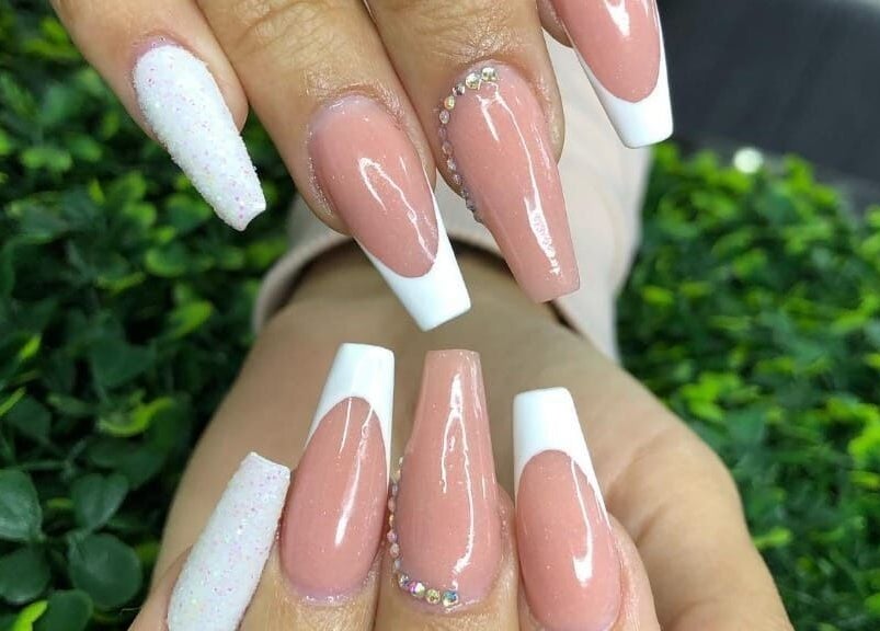 Uñas con manicura francesa en Beauty House, Quito, Pichincha, EC, rodeadas de fondo verde.