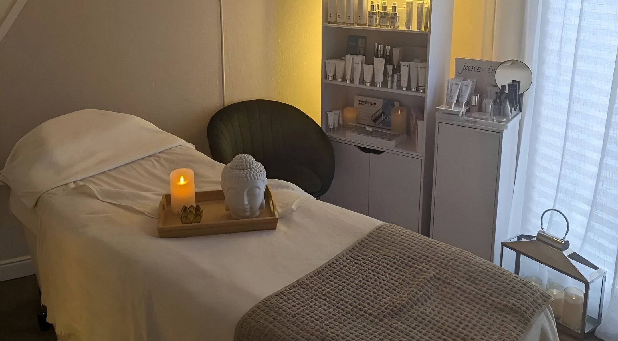 Tranquil spa room at Clare Anne Beauty in Hoddlesden, England, GB with a lit candle and products on display.